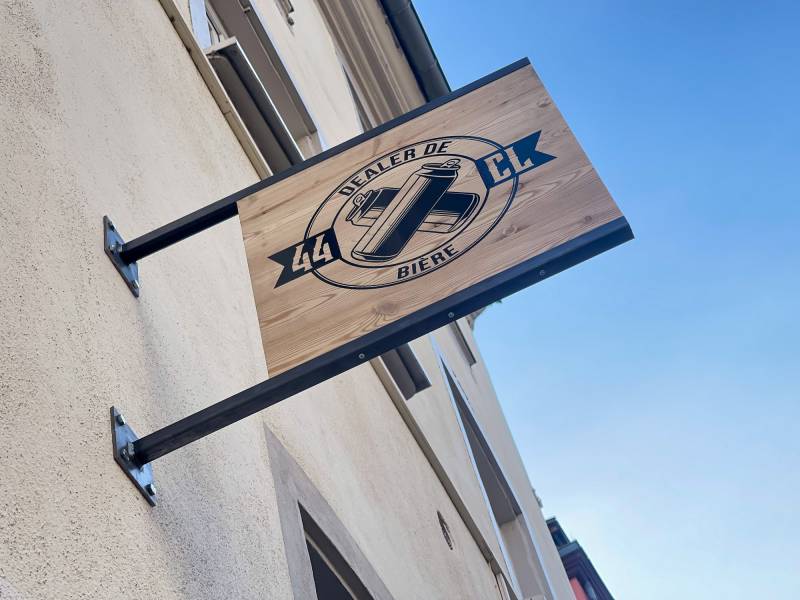 Pose d’une enseigne drapeau en bois pour 44CL à Strasbourg