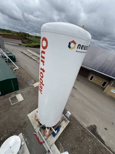 Silo industriel marqué au logo Neustark, illustrant une solution innovante pour la capture et la valorisation permanente du CO₂, situé sur un site industriel écologique