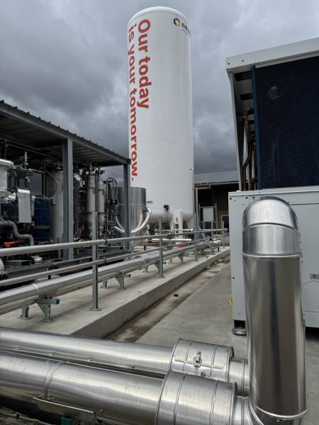 Vue rapprochée d’une infrastructure industrielle comprenant un silo Neustark et un réseau de tuyauterie en acier inoxydable, soulignant l’intégration des solutions de captation du carbone