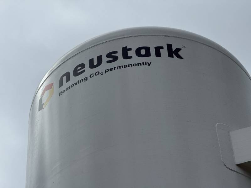 Zoom sur la signalétique Neustark appliquée sur un silo industriel, mettant en avant leur technologie de captation et stockage permanent de CO₂ pour un avenir plus durable